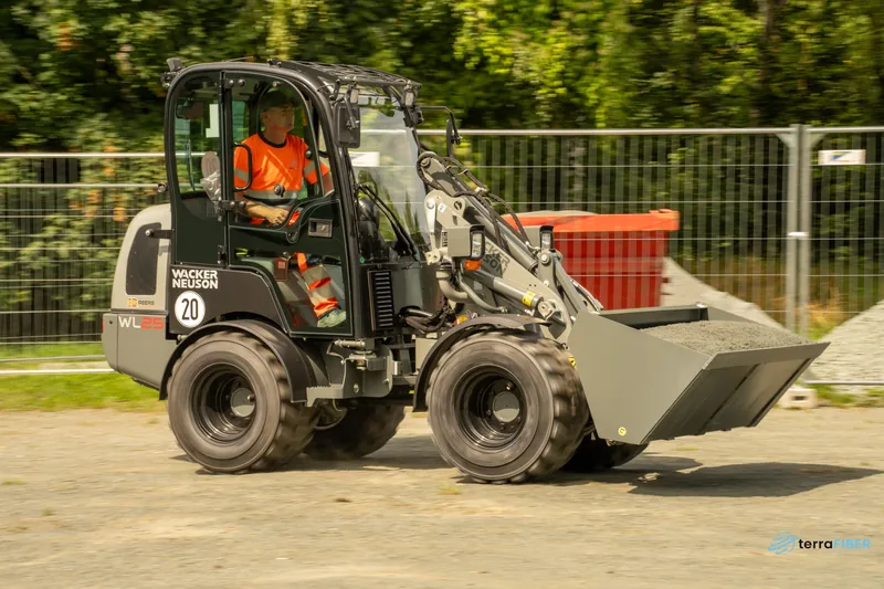 Mitarbeiter fährt einen Radlader auf einer Baustelle